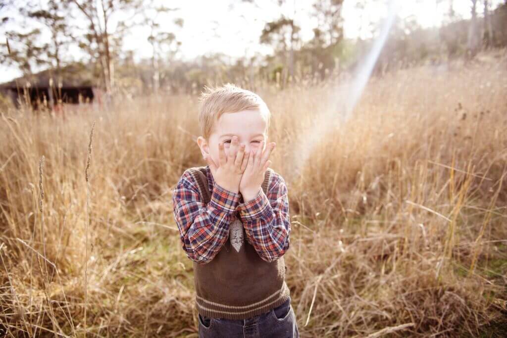 little boy playing outside in field